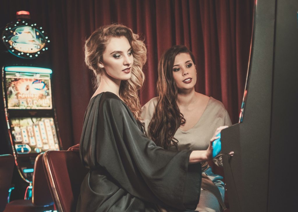 Beautiful women near slots machines in a luxury casino interior
