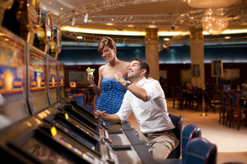 man and woman playing he slot machine
