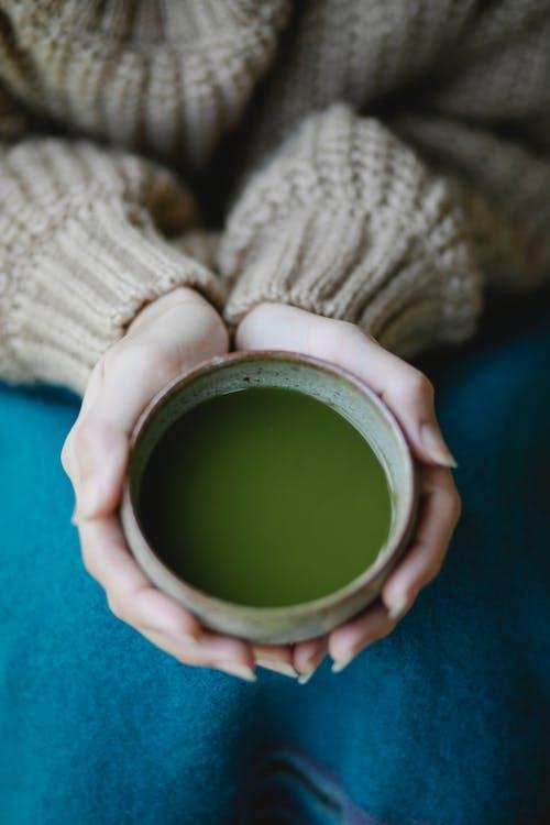 Close up of woman holding cup of matcha