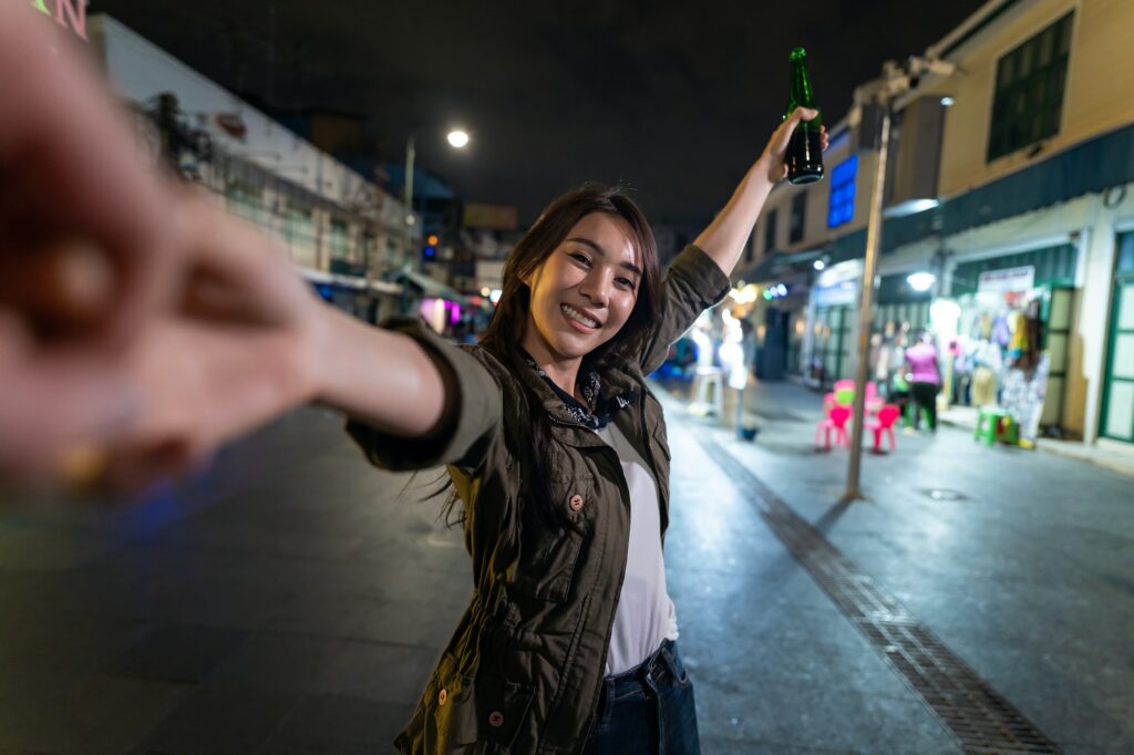 Asian woman backpacker use phone selfie, record vlog on holiday vacation trip in Thailand at night.