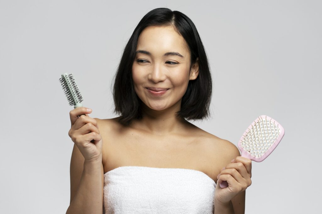 Hair treatment. Portrait of positive brunette woman holding two hair brushes