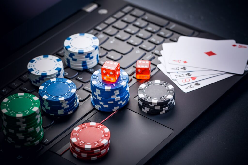 Online poker. Chips, cards and dice nearby keyboard