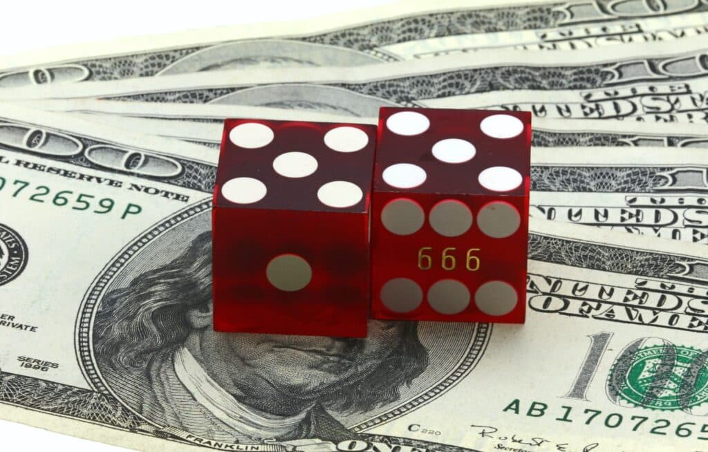 Closeup shot of casino dice on a pile of dollars - gambling concept