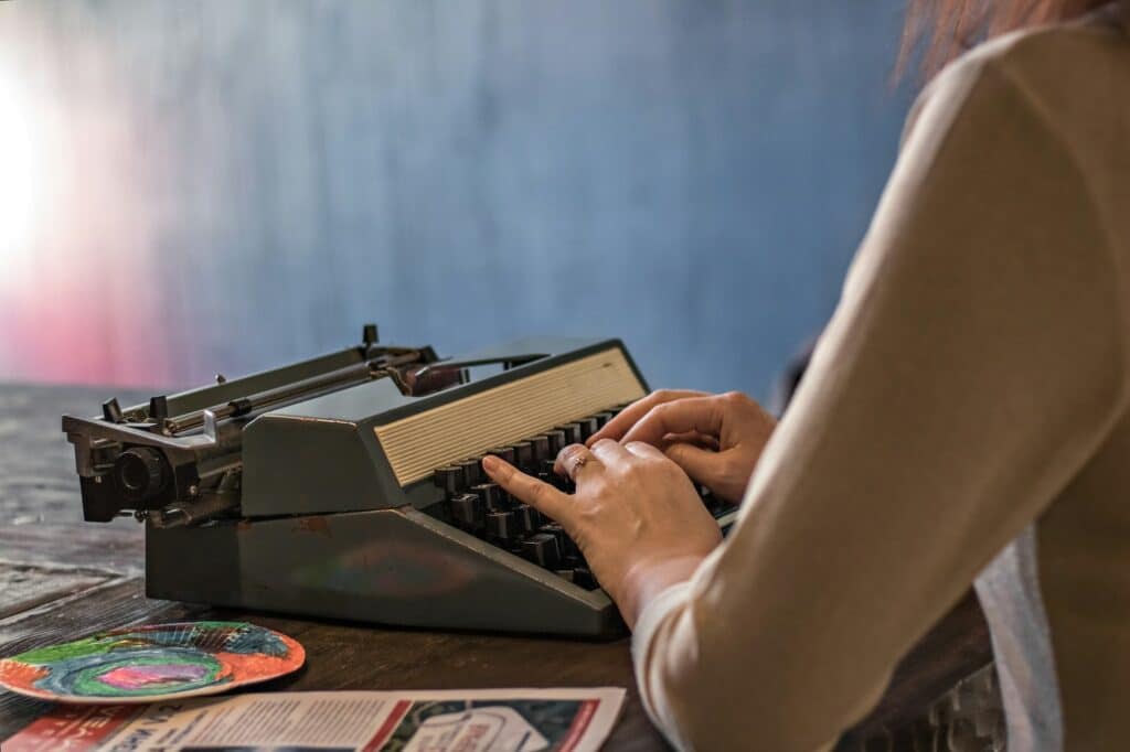 Women's hands on the keys of an old typewriter