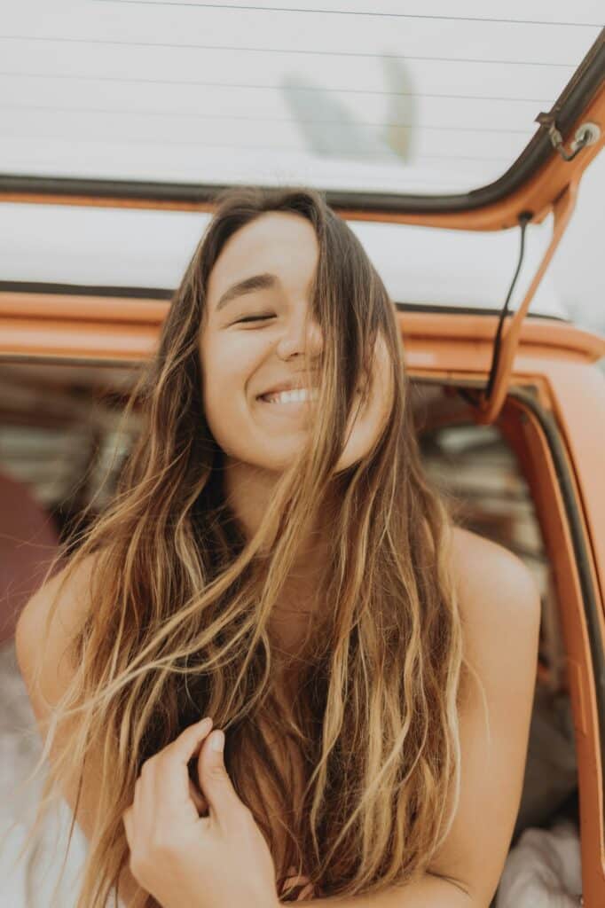 Young woman with eyes closed in back of recreational vehicle, portrait, Jalama, California, USA