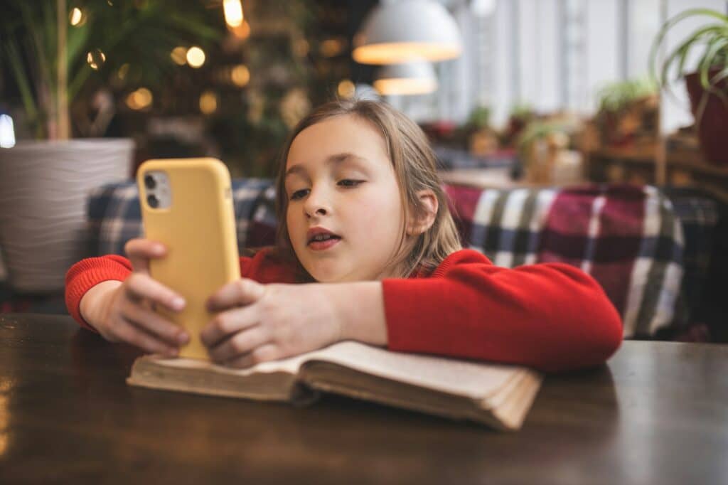 Child addicted to gadgets. Using the phone. The child scrolls on the Internet. Internet addiction.